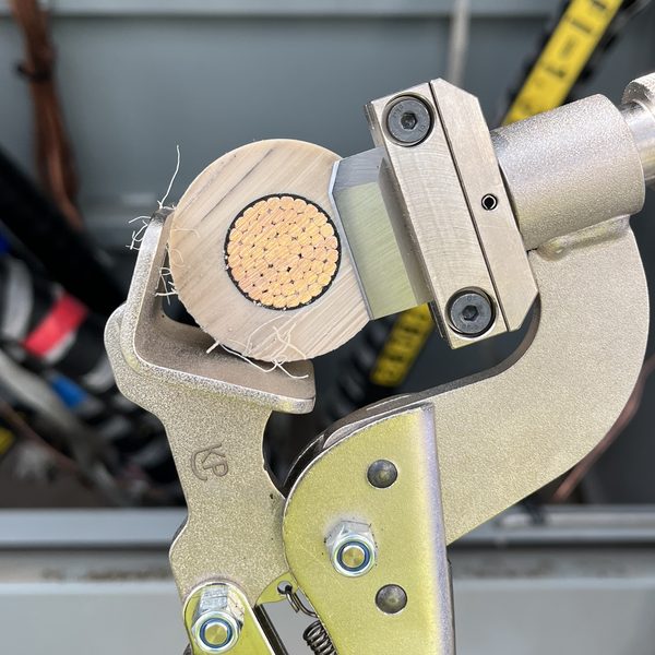 Cut face of a large stranded copper conductor held in a clamping tool
