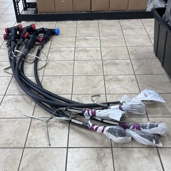Prefabricated medium voltage cable jumpers laid out on a shop floor, elbow ends capped and the opposite terminations taped and bagged
